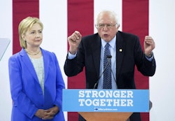Bernie Sanders during his speech next to a "stronger together" speech platform