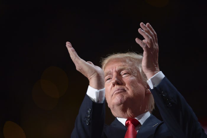 A closeup of Donald Trump clapping on stage