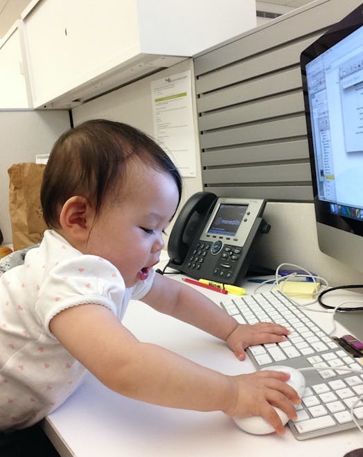 A baby touching a keyboard and a mouse