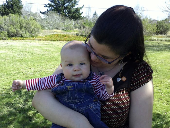 A mom with urinary incontinence, sitting on the grass, holding her kid in her lap 