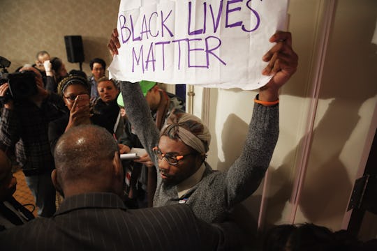 Man holding a black lives matter sign in response to the Philando Castile case
