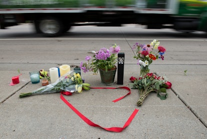 Flowers, candles and red ribbon left on the street in memorial of the dead 
