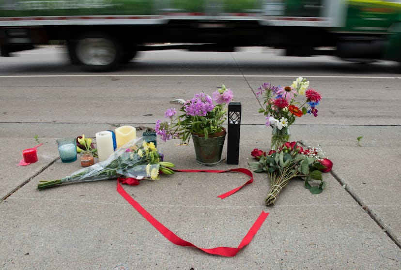 Flowers, candles and red ribbon left on the street in memorial of the dead 