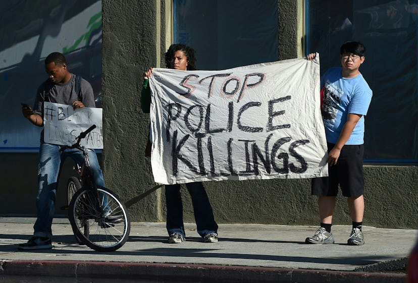 People holding a sign "stop police killings"