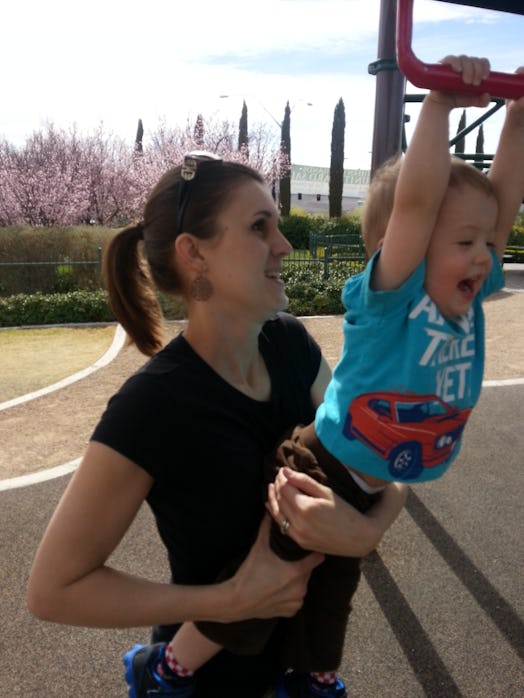 Son of Christi Cazin holds on to a hoop while she holds him