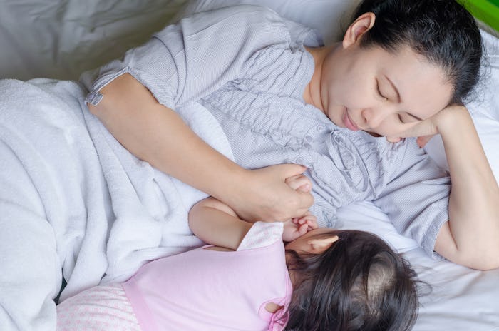 Mom lying in bed while breastfeeding her baby