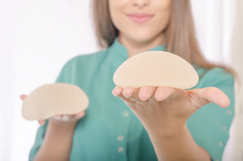 A doctor showing different sizes of breast implants