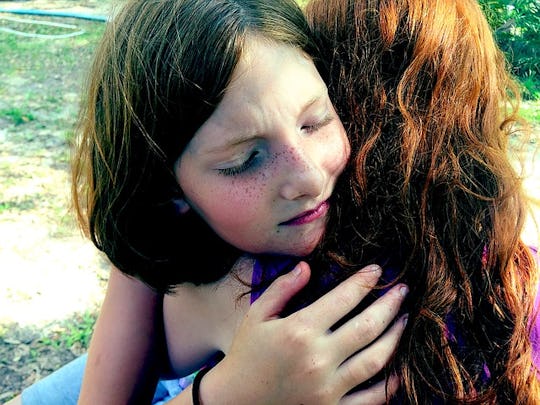 A mom hugging her daughter