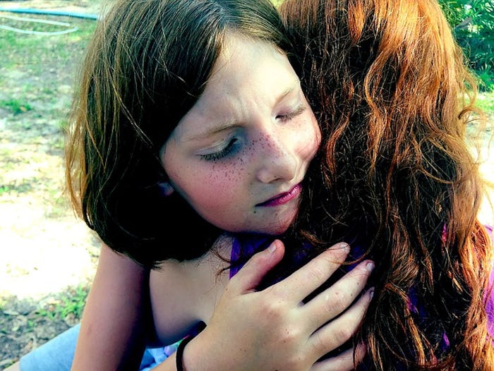 A mom hugging her daughter.