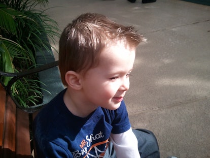 Picture of Christi's son sitting on a bench in the park