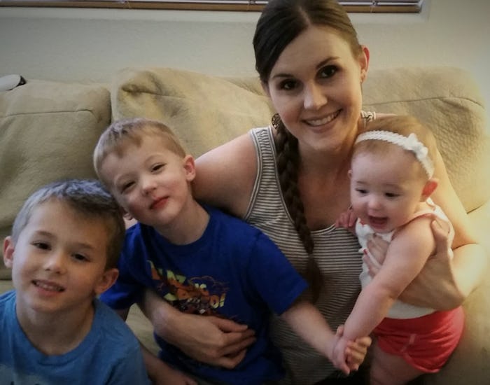 A stay-at-home mom sitting on a couch with her three kids