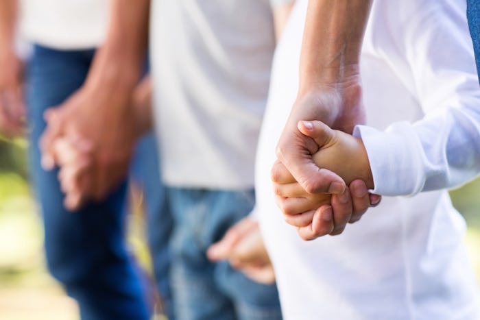 A father and his two sons holding hands.