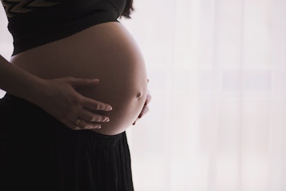 A pregnant woman holding her belly 