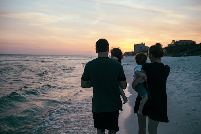 Parents walking with their children on the beach