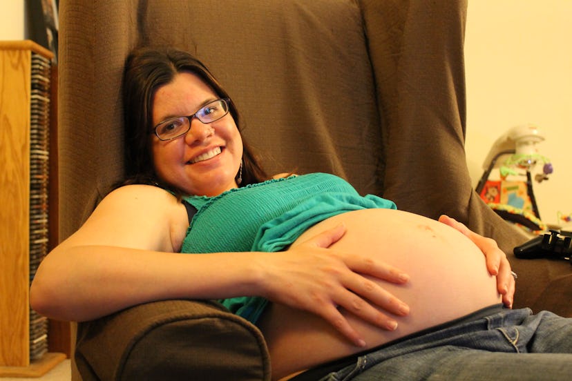 A pregnant woman lying in a green top