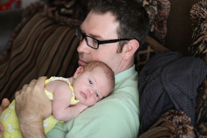 A Samantha's husband holding their daughter on his chest 