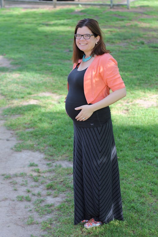 A pregnant Samantha Taylor posing for a picture while holding her belly