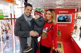 A man and woman with their child who was born via surrogacy, in Christmas outfits