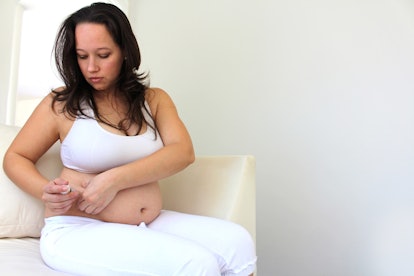 A pregnant woman giving herself a shot due to Gestational Diabetes