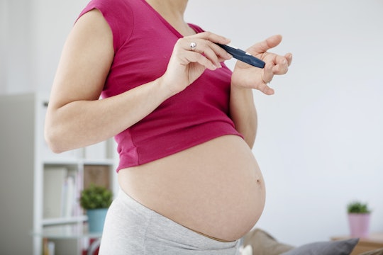 A pregnant woman with a measuring device, who has Gestational Diabetes