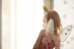 A daughter wearing a costume with wings on her back