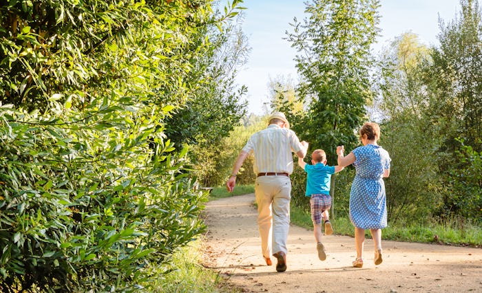 Grandparents walking with their grandkid through a path in nature