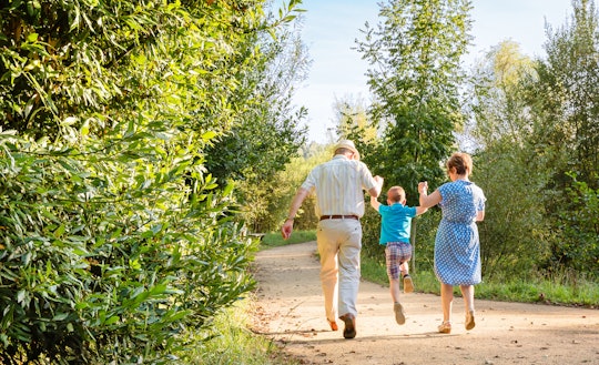 Grandparents walking with their grandkid through a path in nature