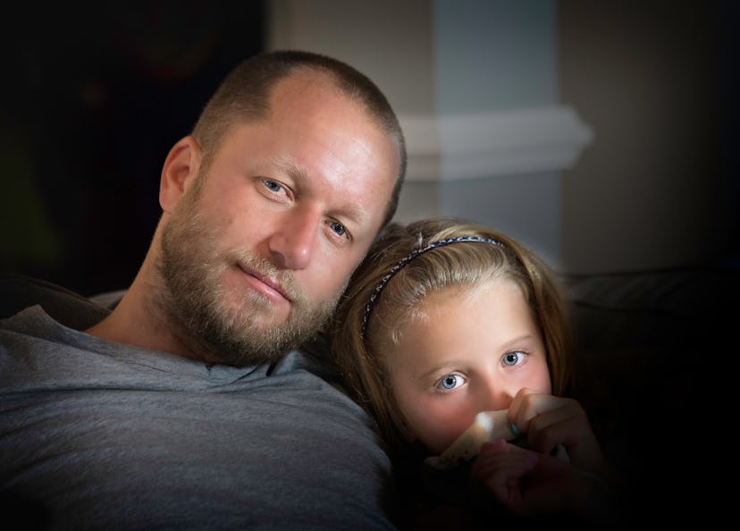 The girl with Leukemia and Her dad posing together on a couch