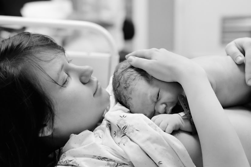 A woman holding her newborn on her chest immediately after giving birth