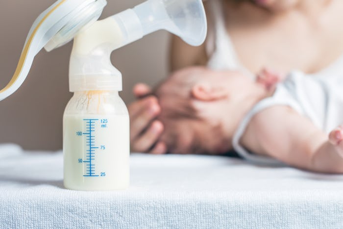 A blurred image of a mother and baby, with a bottle equipped with a breast pump fully visible in the...