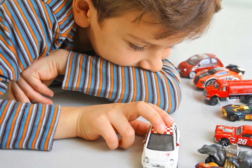 A boy playing with his cars