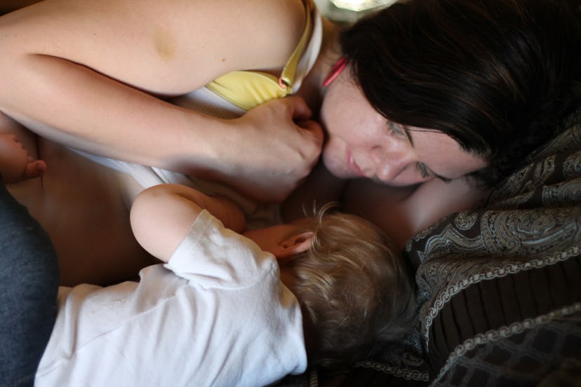 A mom lying and breastfeeding a baby.
