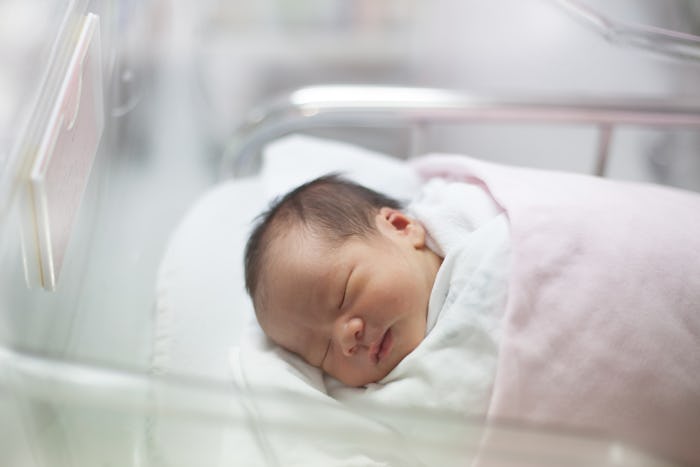 A newborn baby sleeping in the hospital nursery