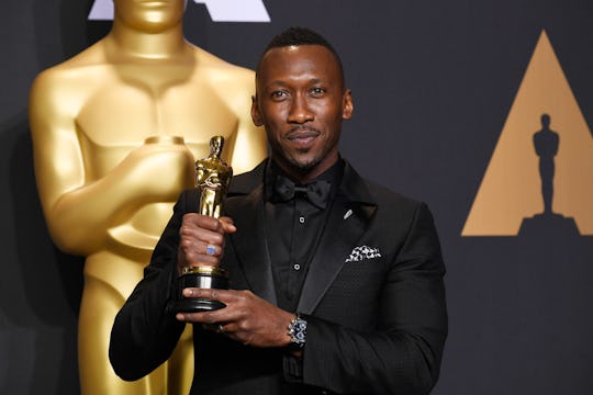 Actor Mahershala Ali holding his Oscar award.