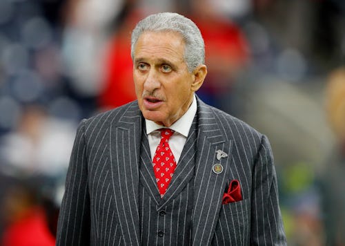 Arthur Blank in a striped blazer and vest with a red tie looking into the distance