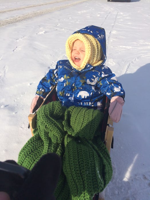 Toddler in his winter suit, enjoying the snow