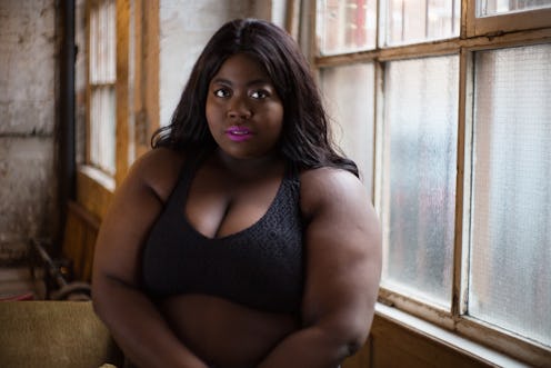 Stephanie Yeboah sitting in a black bra in front of a window