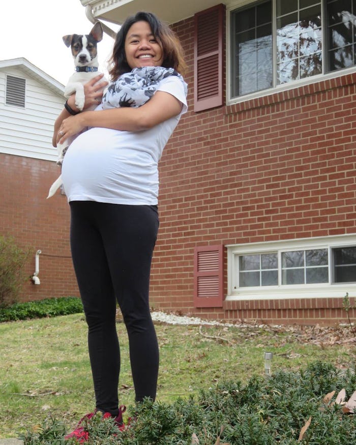 A pregnant woman, who scheduled her C-section, holding her dog in her arms 