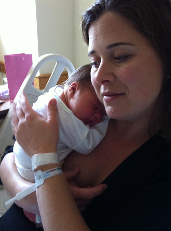 A woman who has switched to formula, holding her newborn baby on her chest