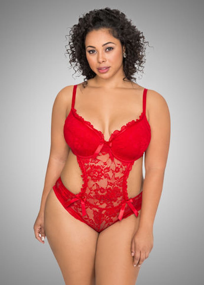 A plus size model posing in a red backless teddy bodysuit