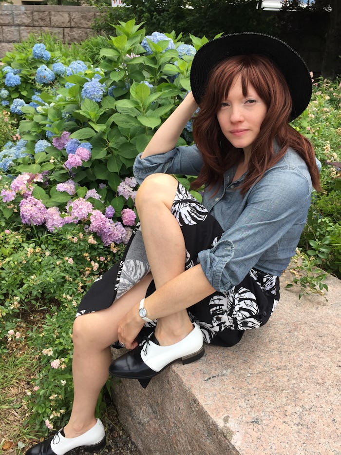 A woman letting pressure go while sitting in a garden