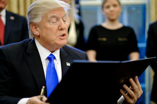 Donald Trump reading a document he signed.