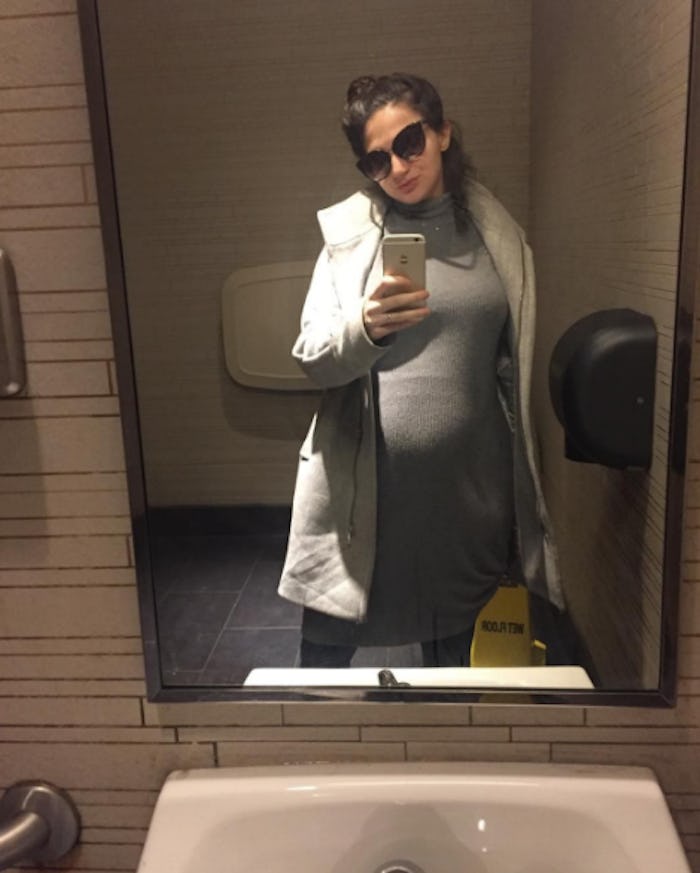 Elisabeth Jill (EJ) Dickson pregnant taking a mirror selfie in sunglasses, a grey top and light grey...