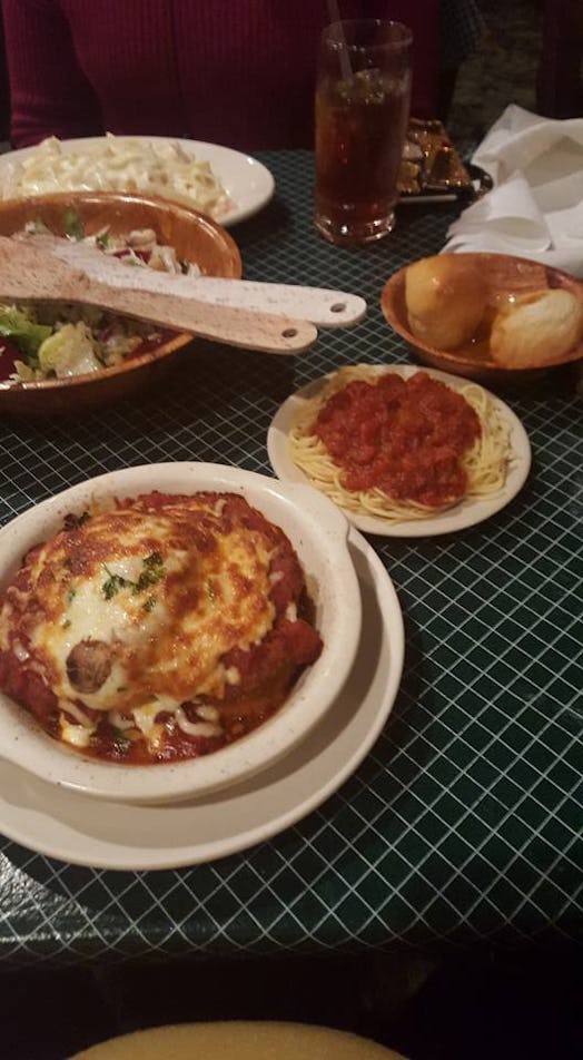 Image of a dinner table with eggplant parmesan, spaghetti bolognese, and salad