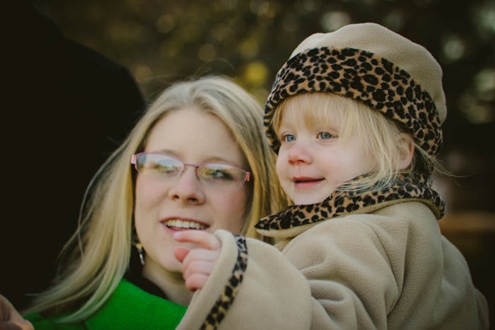 Crystal Henry holding her daughter wearing a beige coat with a leopard print and a matching hat