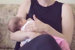 A mother holding her baby while sitting