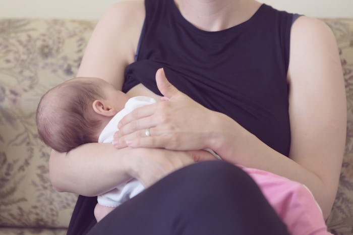 A mother holding her baby while sitting