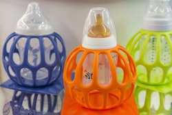 Three baby bottles along with their multicolored covers