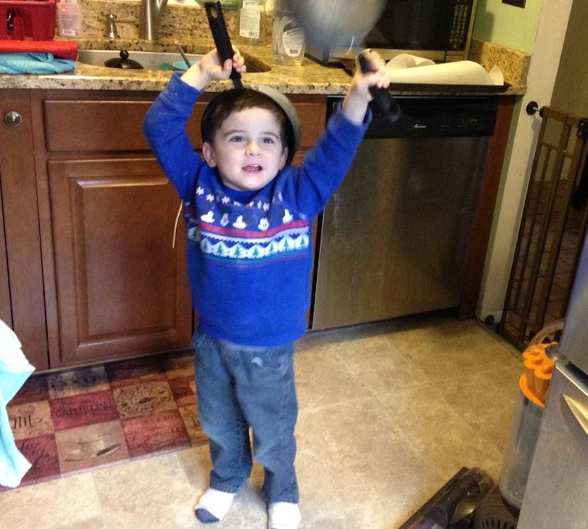 A 4-year-old playing with pots and pans in the kitchen