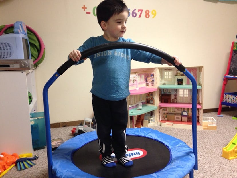 A boy standing on an indoor trampoline